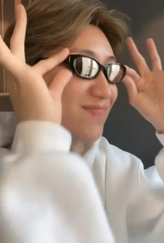 A Man Wearing Sunglasses Makes A Funny Face With His Hands GIF