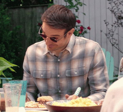 A Man Wearing Sunglasses Sits At A Table With Food GIF