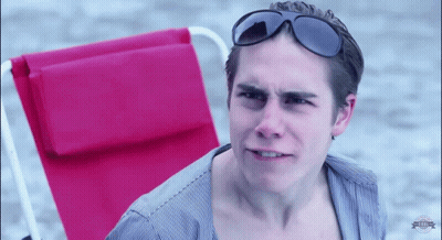 A Man Wearing Sunglasses Sitting In A Red Chair GIF