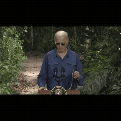 A Man Wearing Sunglasses Stands Behind A Podium With A United States Seal On It GIF