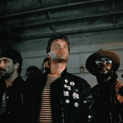 A Man Wearing Sunglasses Stands In Front Of A Cage GIF