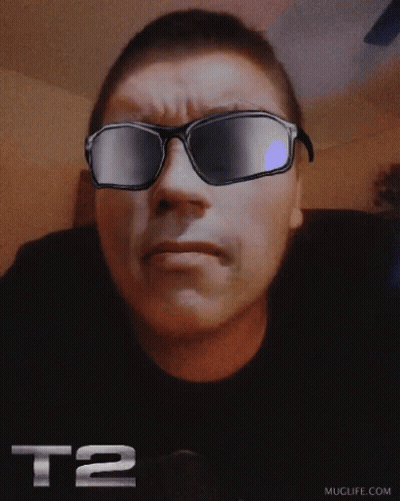 A Man Wearing Sunglasses With The Letters T2 On His Shirt GIF