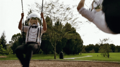 A Man Wearing Suspenders And A Helmet Swings On A Swing GIF