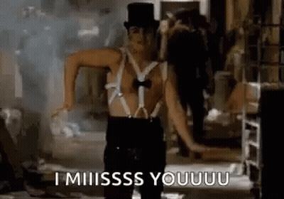 A Man Wearing Suspenders And A Top Hat Is Dancing In A Room . GIF