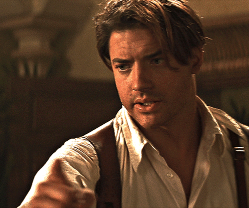 A Man Wearing Suspenders And A White Shirt Is Looking At Something GIF