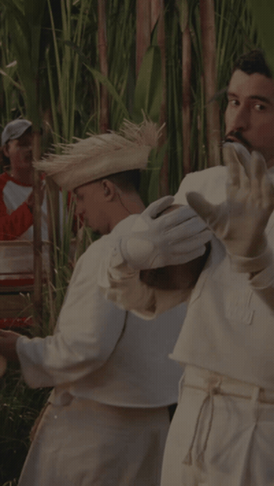 A Man Wearing White Gloves And A Straw Hat Is Playing A Musical Instrument GIF