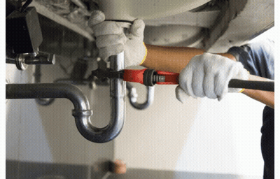 A Man Wearing White Gloves Is Working On A Pipe With A Wrench GIF