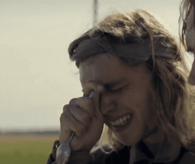 a man wipes his eyes with a fork