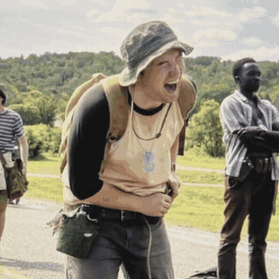 A Man With A Backpack Is Laughing While Another Man Looks On GIF