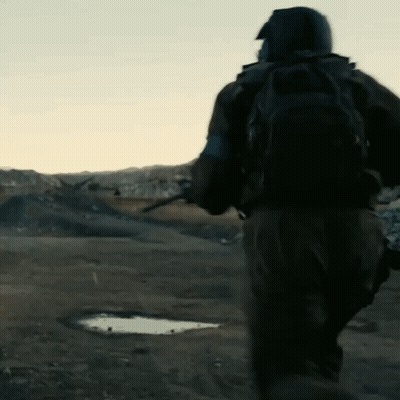 A Man With A Backpack Is Running In The Desert GIF
