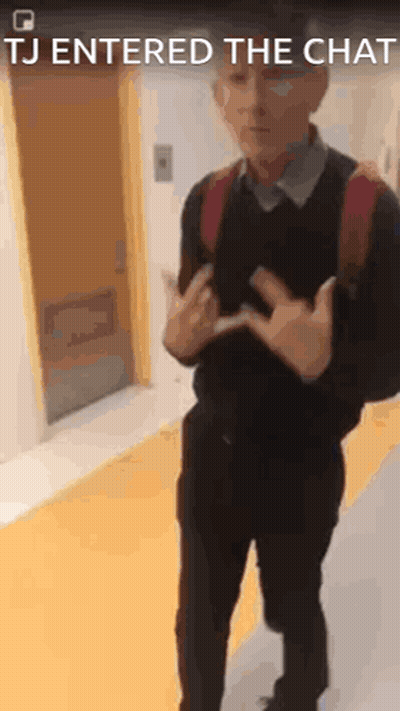 A Man With A Backpack Is Standing In A Hallway With The Words Tj Entered The Chat Above Him . GIF