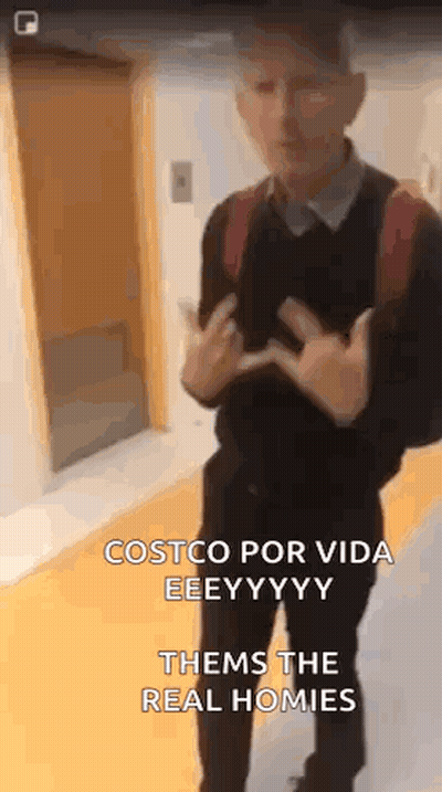 A Man With A Backpack Is Standing In Front Of A Door And Giving The Middle Finger . GIF