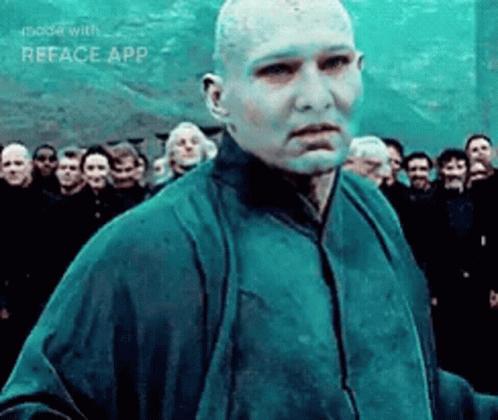 A Man With A Bald Head Is Standing In Front Of A Crowd Of People . GIF