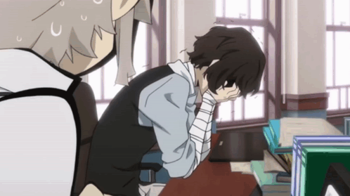 Man With Bandage Sitting At Desk With Head In Hands GIF