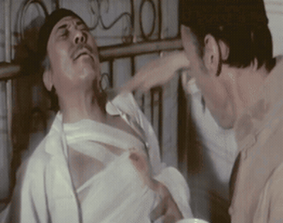 A Man With A Bandage On His Chest Is Being Hit By Another Man GIF