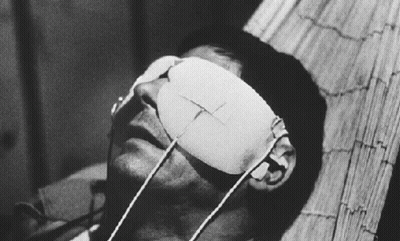 A Man With A Bandage On His Eye Is Laying On A Bed GIF