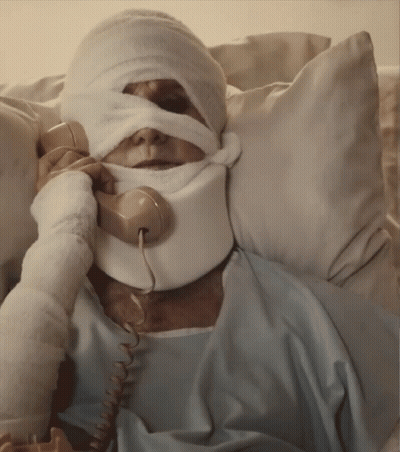 A Man With A Bandage On His Face Is Talking On A Telephone GIF