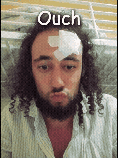 A Man With A Bandage On His Forehead Has The Word Ouch Written Above Him GIF