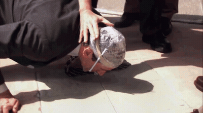 A Man With A Bandage On His Head Is Kneeling Down On The Ground GIF