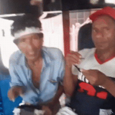 A Man With A Bandage On His Head Is Sitting Next To Another Man Wearing A Red Hat GIF