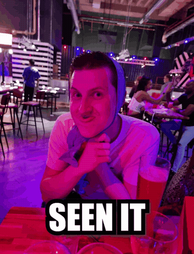 A Man With A Bandage On His Head Sits At A Table With A Sign That Says Seen It On It GIF