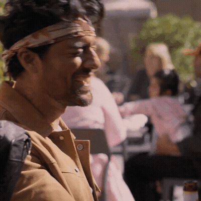 A Man With A Bandana On His Head Is Laughing At Something GIF