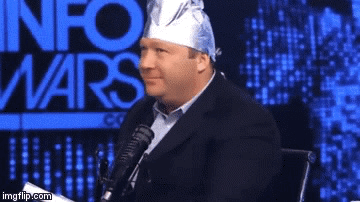 A Man With A Bandana On His Head Is Sitting In Front Of A Microphone With The Words Info Wars Behind Him GIF