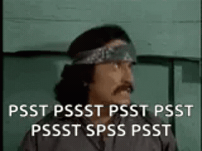 A Man With A Bandana On His Head Is Standing In Front Of A Green Wall . GIF