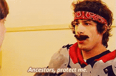 A Man With A Bandana On His Head Is Talking To Another Man And Says Ancestors Protect Me GIF