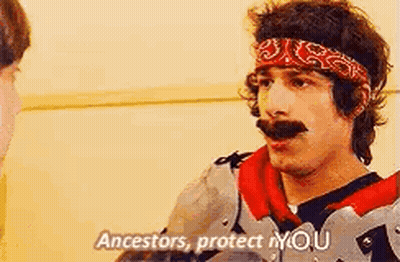 A Man With A Bandana On His Head Is Talking To Another Man While Wearing Armor . GIF