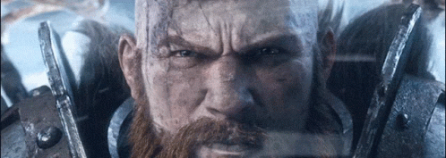 A Man With A Beard And A Bald Head Is Wearing Armor . GIF
