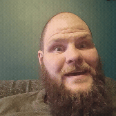A Man With A Beard And A Bald Head Looks Down At The Camera GIF
