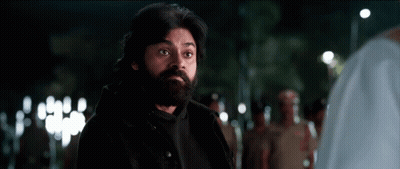 A Man With A Beard And A Black Jacket Is Standing In A Crowd Of People . GIF