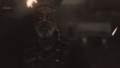 A Man With A Beard And A Black Shirt Is Looking At The Camera With A Blurred Background That Says Kimbal.co GIF