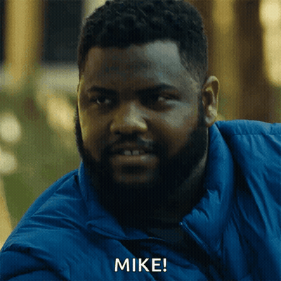 A Man With A Beard And A Blue Jacket Is Saying Mike GIF