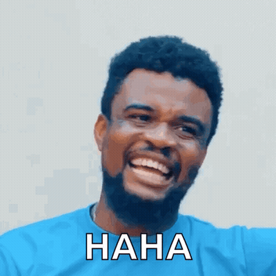 A Man With A Beard And A Blue Shirt Is Laughing With The Words `` Haha '' Written On His Face . GIF