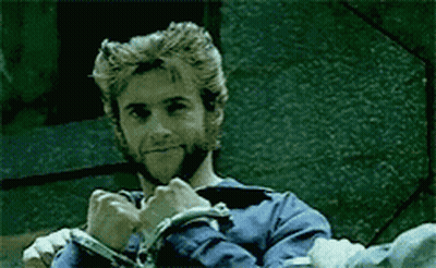 A Man With A Beard And A Blue Shirt Is Wearing Handcuffs GIF