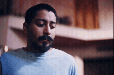 A Man With A Beard And A Blue Shirt Looks Down GIF