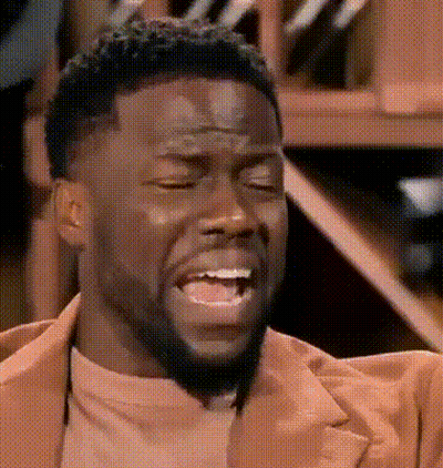A Man With A Beard And A Brown Jacket Is Making A Funny Face . GIF