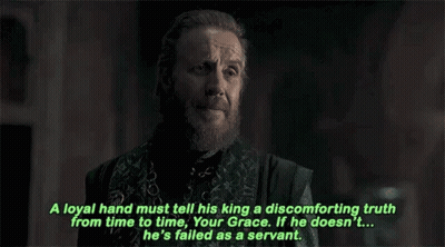 a man with a beard and a chain around his neck is talking to another man .