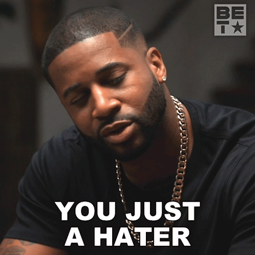 A Man With A Beard And A Chain Around His Neck Says " You Just A Hater " GIF