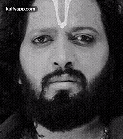 A Man With A Beard And A Cross On His Forehead Is Making A Funny Face . GIF