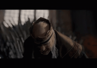 A Man With A Beard And A Crown On His Head Looks To The Side GIF