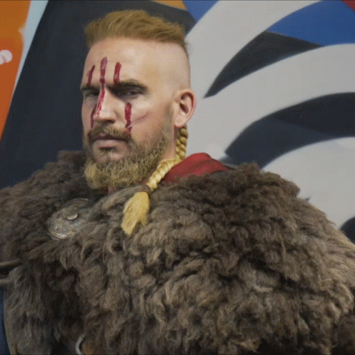 A Man With A Beard And A Fur Coat Has Blood Dripping From His Face GIF