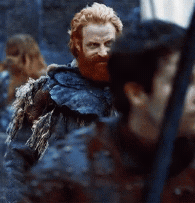 A Man With A Beard And A Fur Coat Is Standing Next To A Woman . GIF