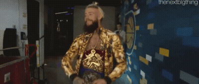 A Man With A Beard And A Gold Jacket Is Standing In Front Of A Wall . GIF