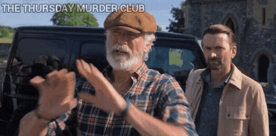 A Man With A Beard And A Hat Is Standing Next To Another Man In Front Of A Van . GIF