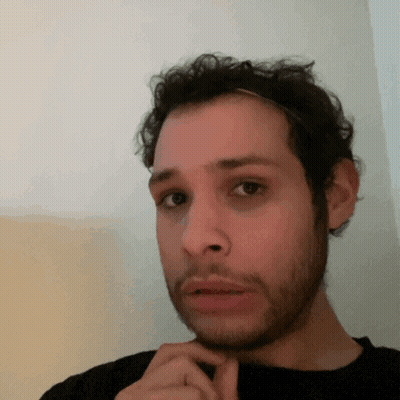 A Man With A Beard And A Headband On His Head Looks At The Camera GIF