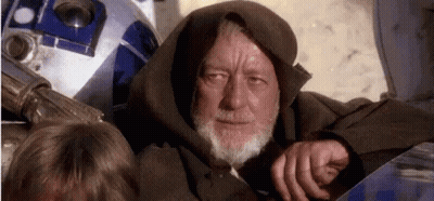 A Man With A Beard And A Hood Is Sitting Next To A R2d2 . GIF