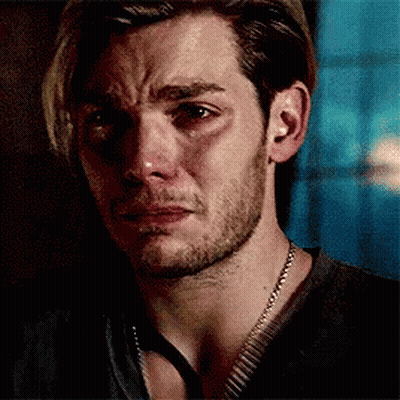 A Man With A Beard And A Necklace Is Crying . GIF